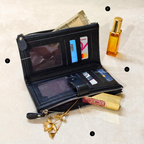 Black wallet with compartments for cards and a phone, next to a perfume bottle on a light background
