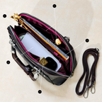 Black handbag with gold accents on a beige background