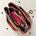 Brown leather handbag with jewelry on a beige background