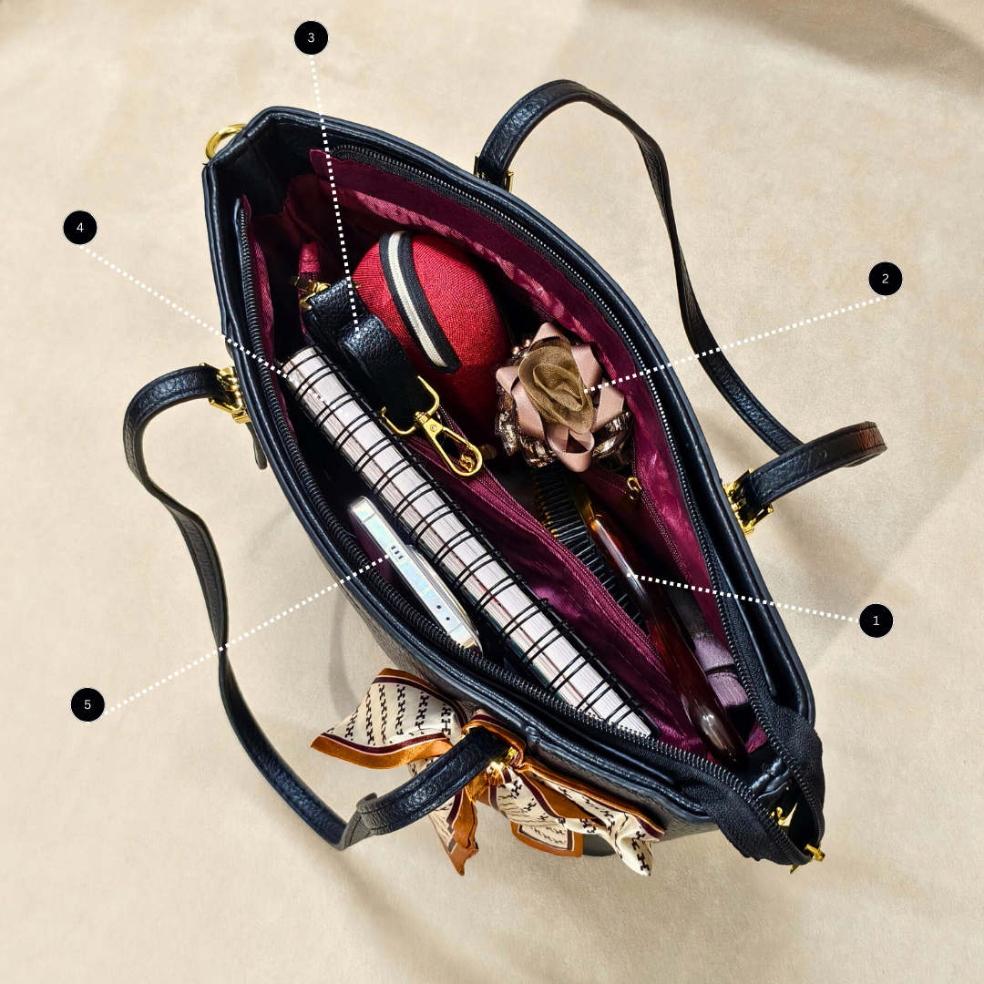 Open handbag with items including a notebook, pen, and decorative elements on a beige background