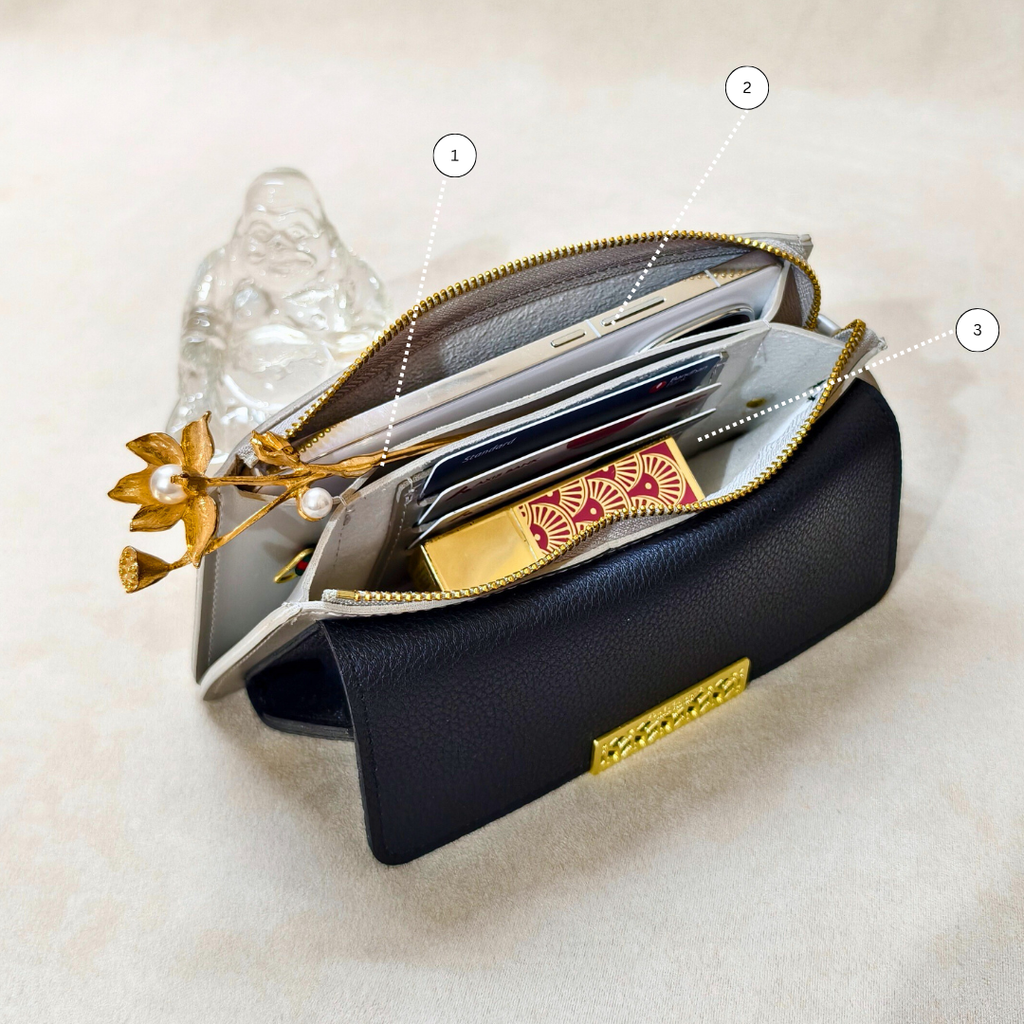 Black clutch with gold accents on a light beige background