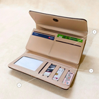 Open beige wallet with card slots and a small screen on a beige background