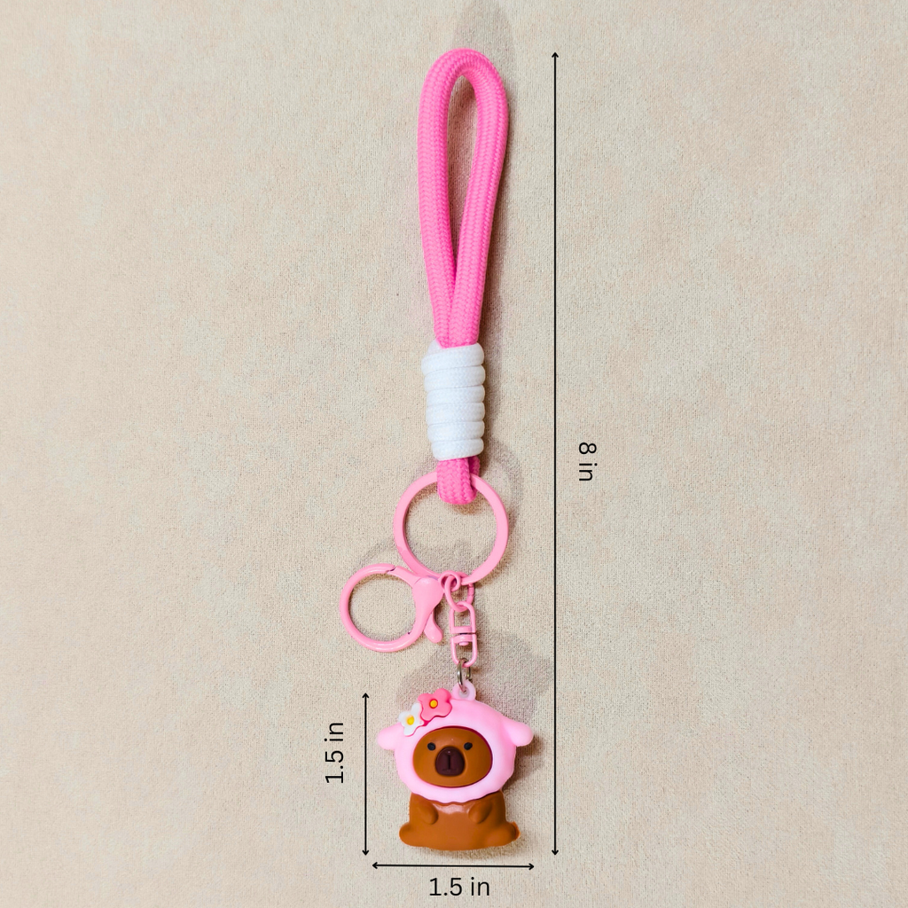 Pink keychain with a bear charm on a beige background