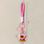 Pink keychain with a bear charm on a beige background