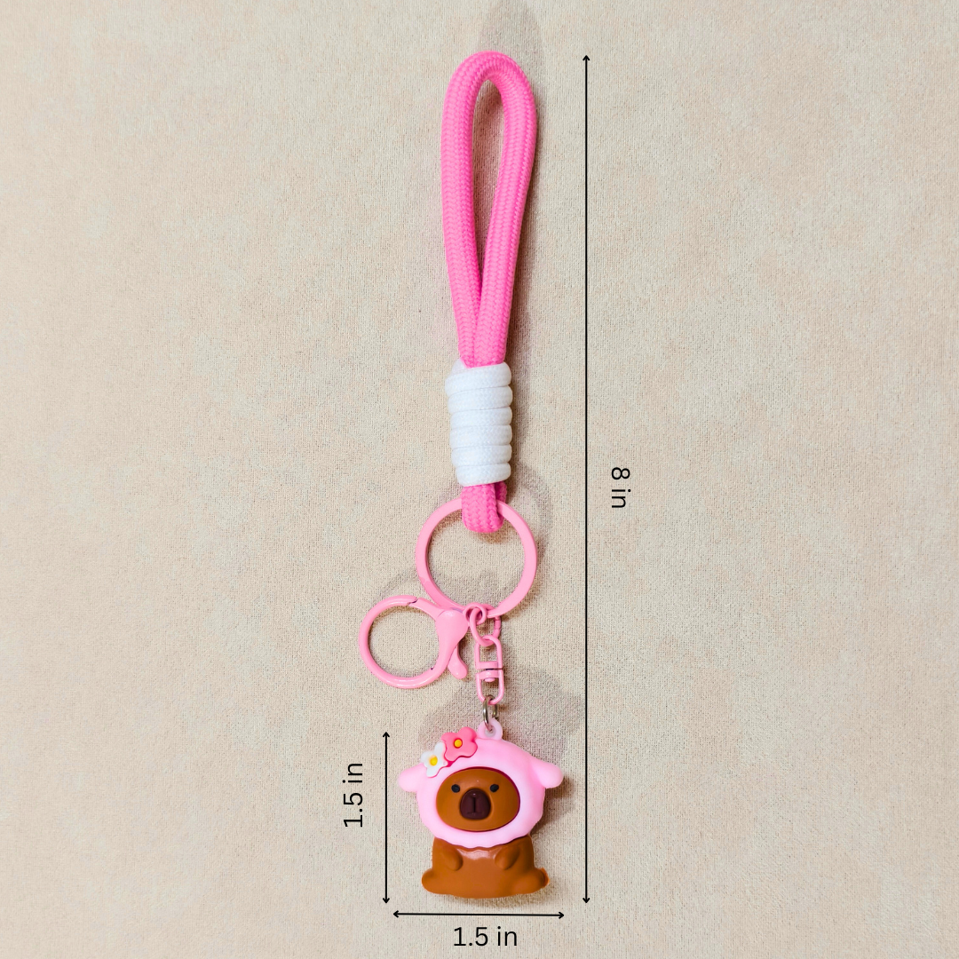 Pink keychain with a bear charm on a beige background