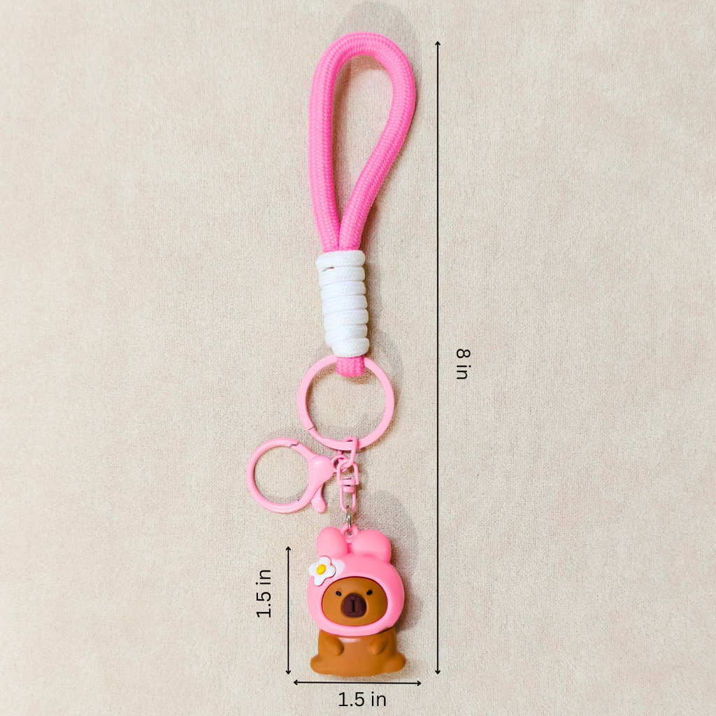 Pink keychain with a bear charm on a beige background