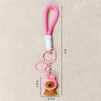 Pink keychain with a bear charm on a beige background