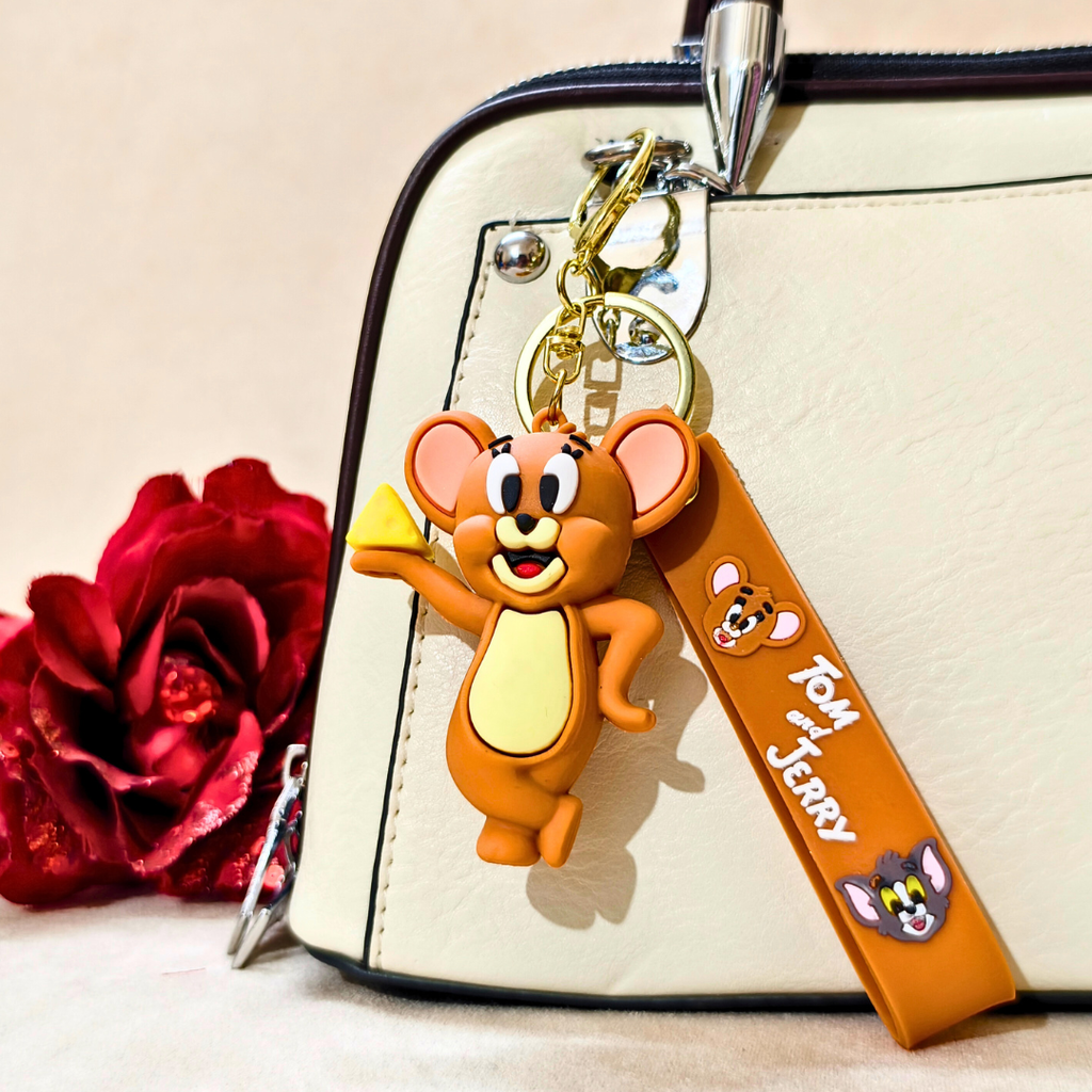 Keychain with cartoon character attached to a bag next to a red rose