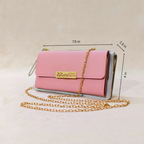 Pink handbag with gold chain and measurements on a beige background