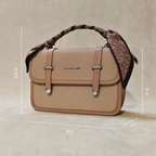 Beige handbag with decorative strap on a beige background, showing dimensions.