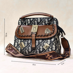 Designer handbag with monogram pattern and brown accents, shown with measurements on a beige background.