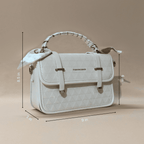 White quilted handbag with dimensions on a beige background