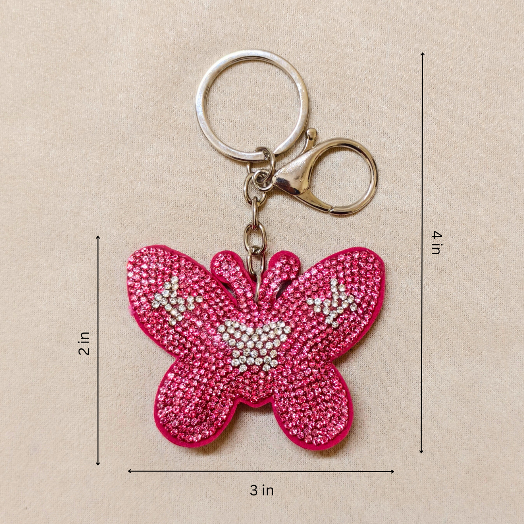 Pink butterfly keychain with measurements on a beige background