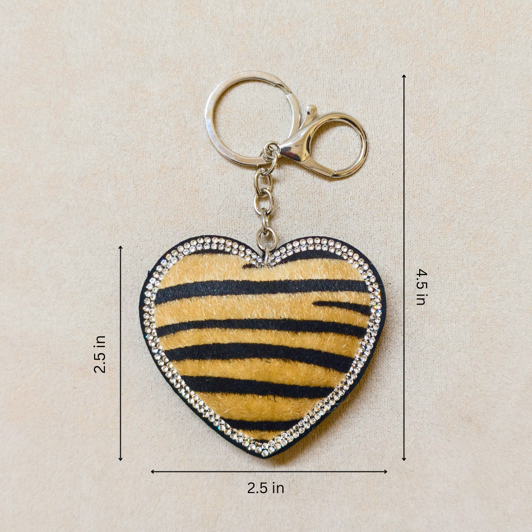 Heart-shaped keychain with zebra pattern and measurements on a beige background