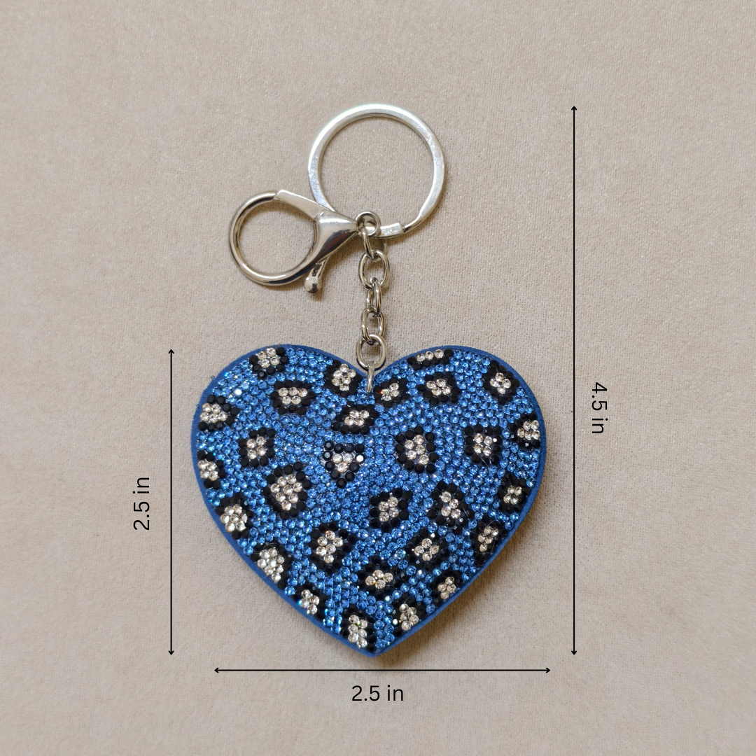 Blue heart-shaped keychain with black and white pattern and measurements on a beige background