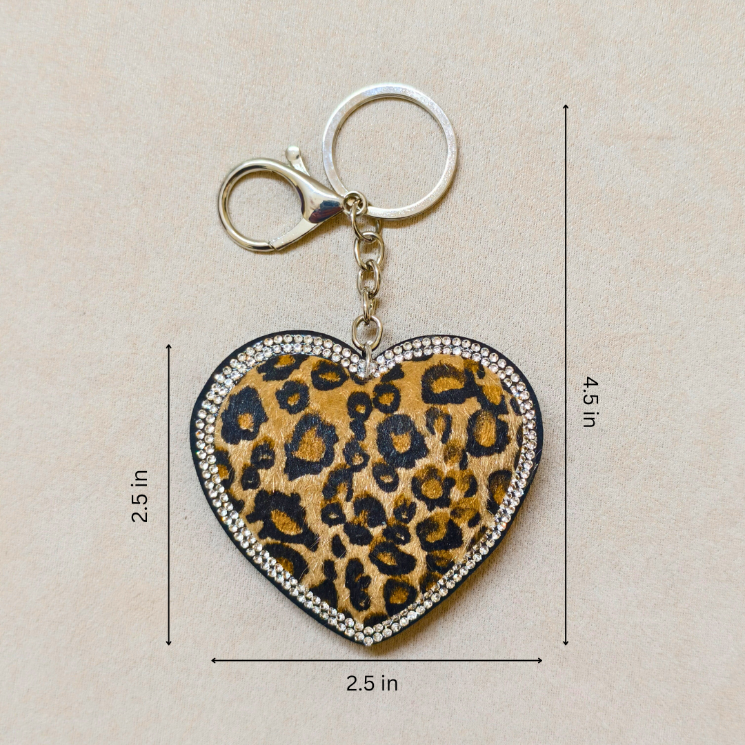 Heart-shaped keychain with leopard print design and measurements on a beige background