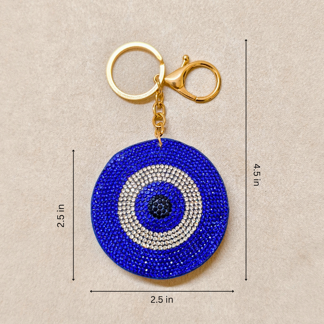 Blue evil eye keychain with measurements on a beige background