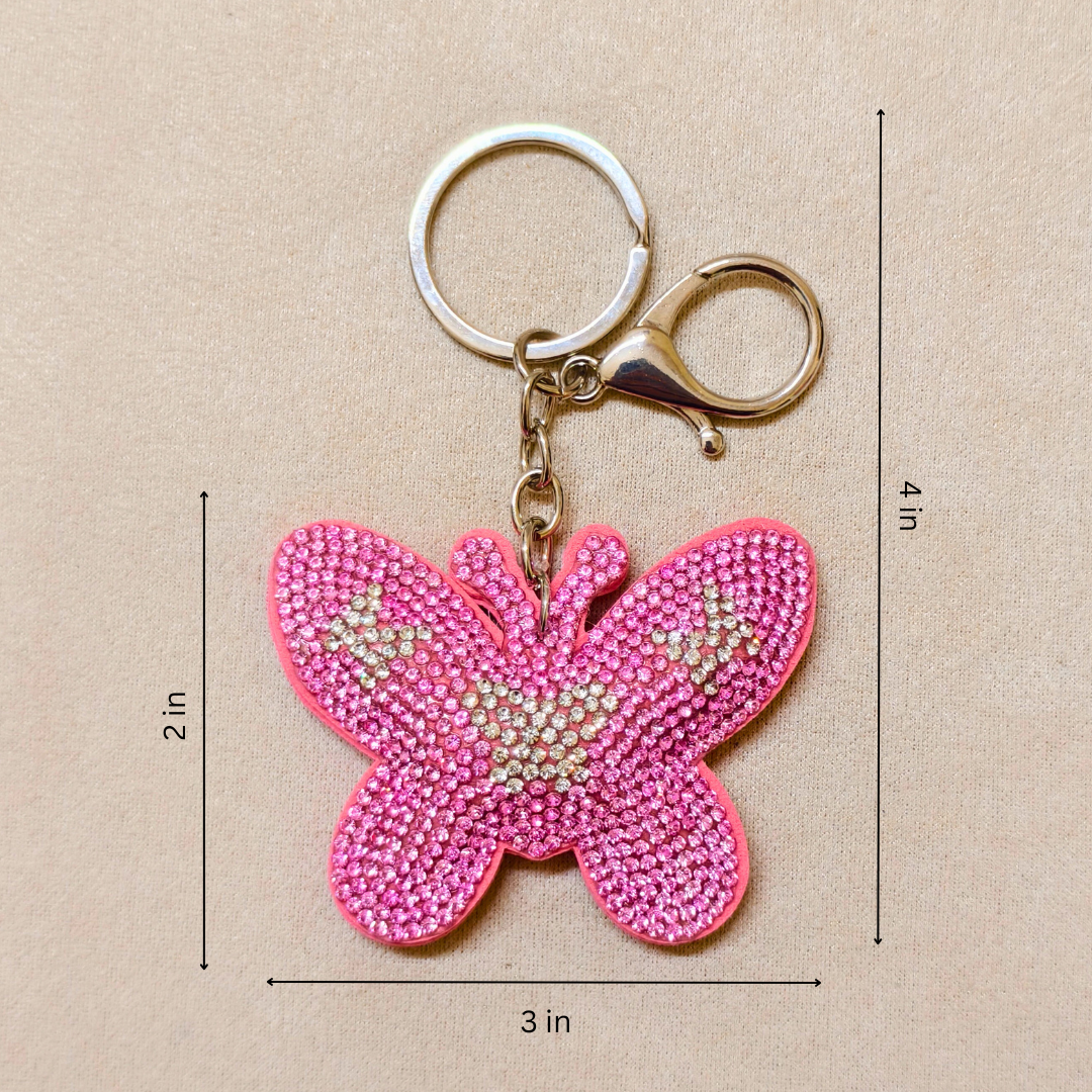 Pink butterfly keychain with measurements on a beige background