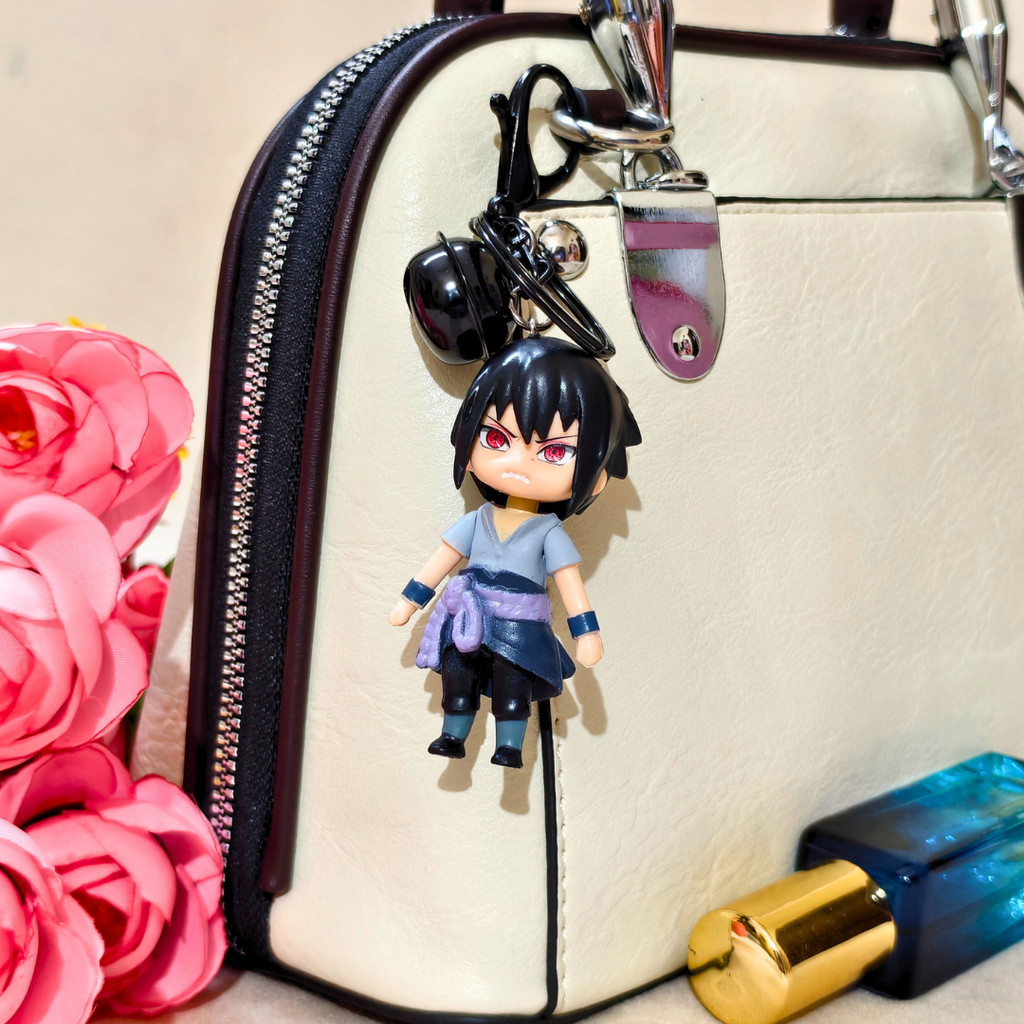 Keychain with a character attached to a beige handbag with pink flowers and a blue lip gloss in the background.